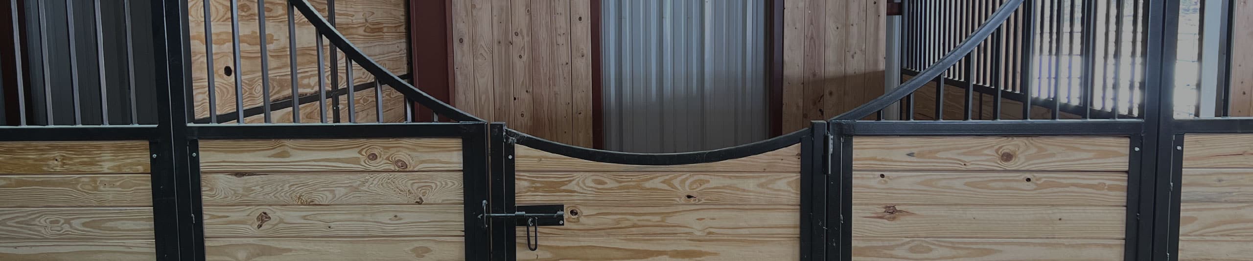 Custom barn stalls with black metal framing and wood fill.