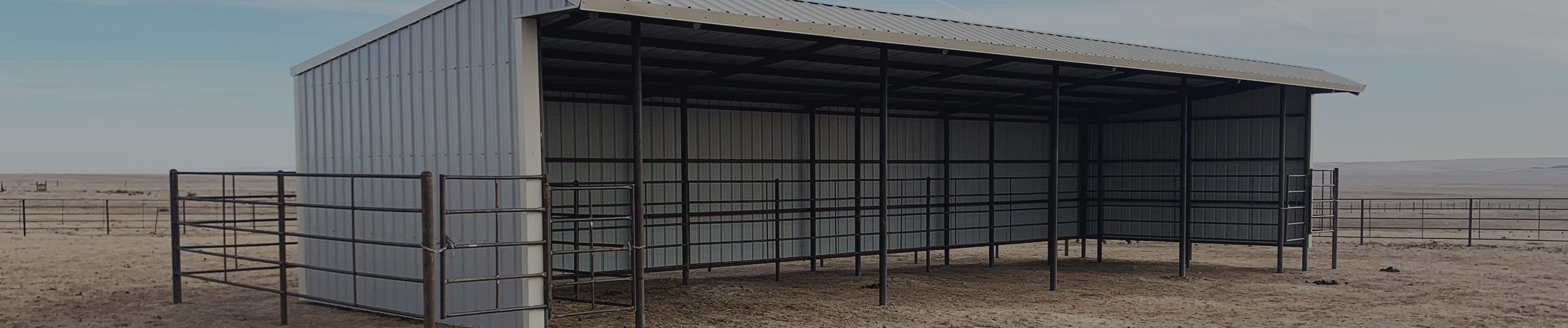 Portable run in loafing shed with steel pipe fence runs for horses in pasture.