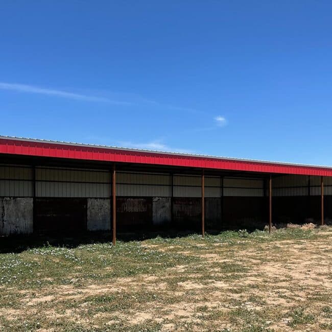 Weld-up metal building with stalls and red siding