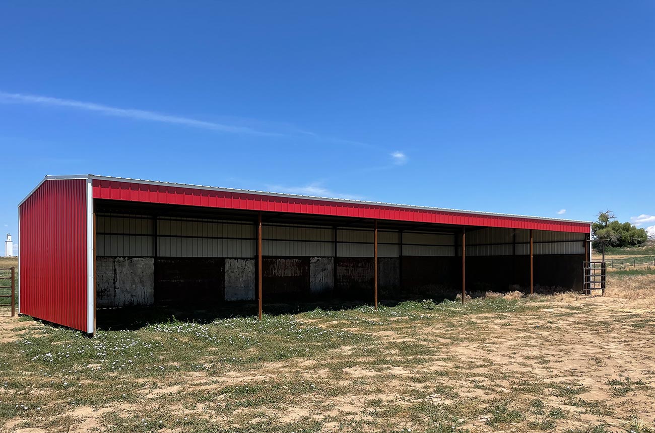 Weld-up metal building with stalls and red siding