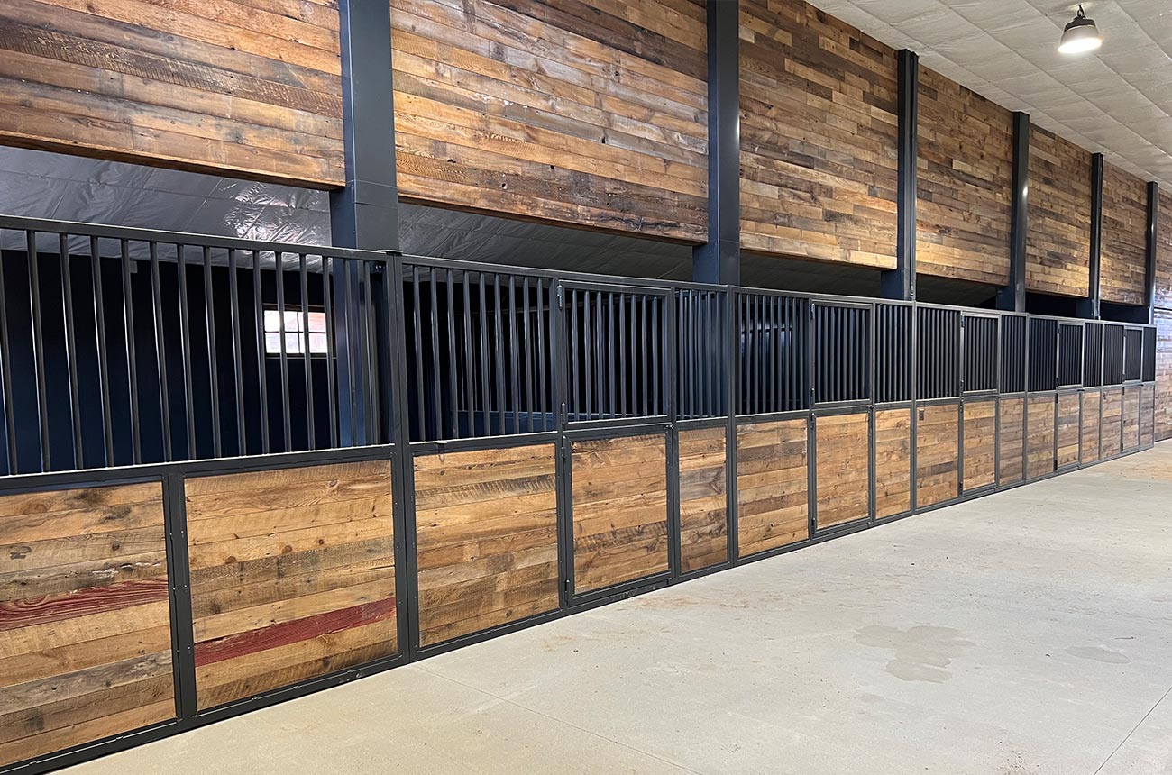 Custom barn stalls with dark wood and black metal framing