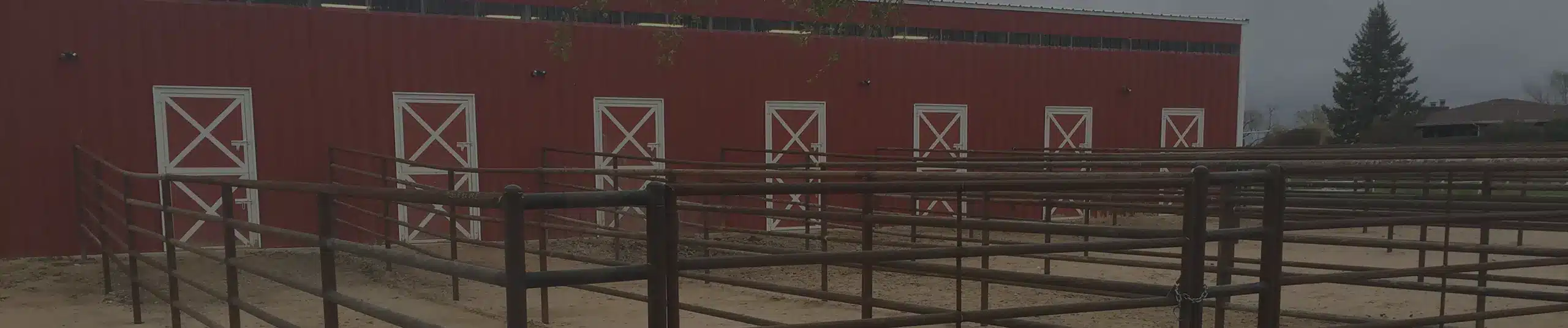 Custom barn with custom barn doors and metal pipe fence built by Port A Stall